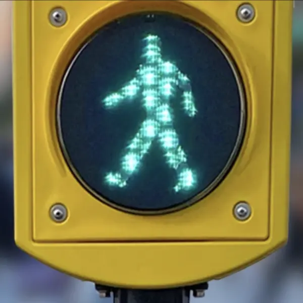 Pedestrian traffic signal showing green walking man.